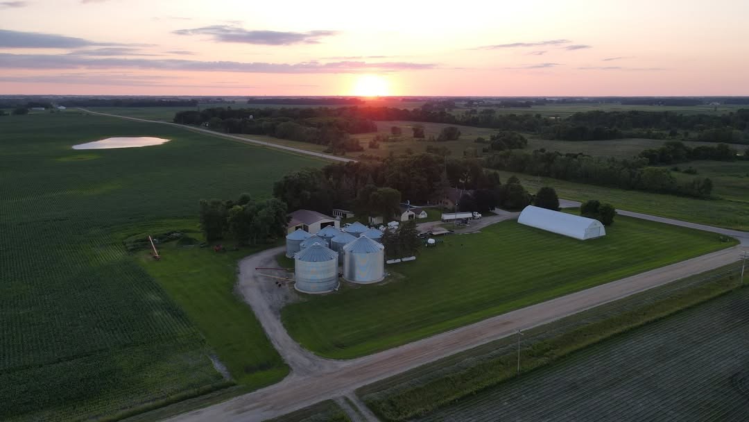 Aerial view of the farmstead with grain bins at sunset